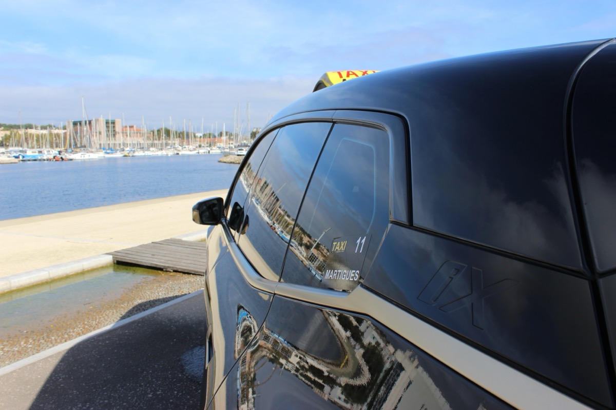 Enseigne Taxi Martigues avec le port en arrière-plan